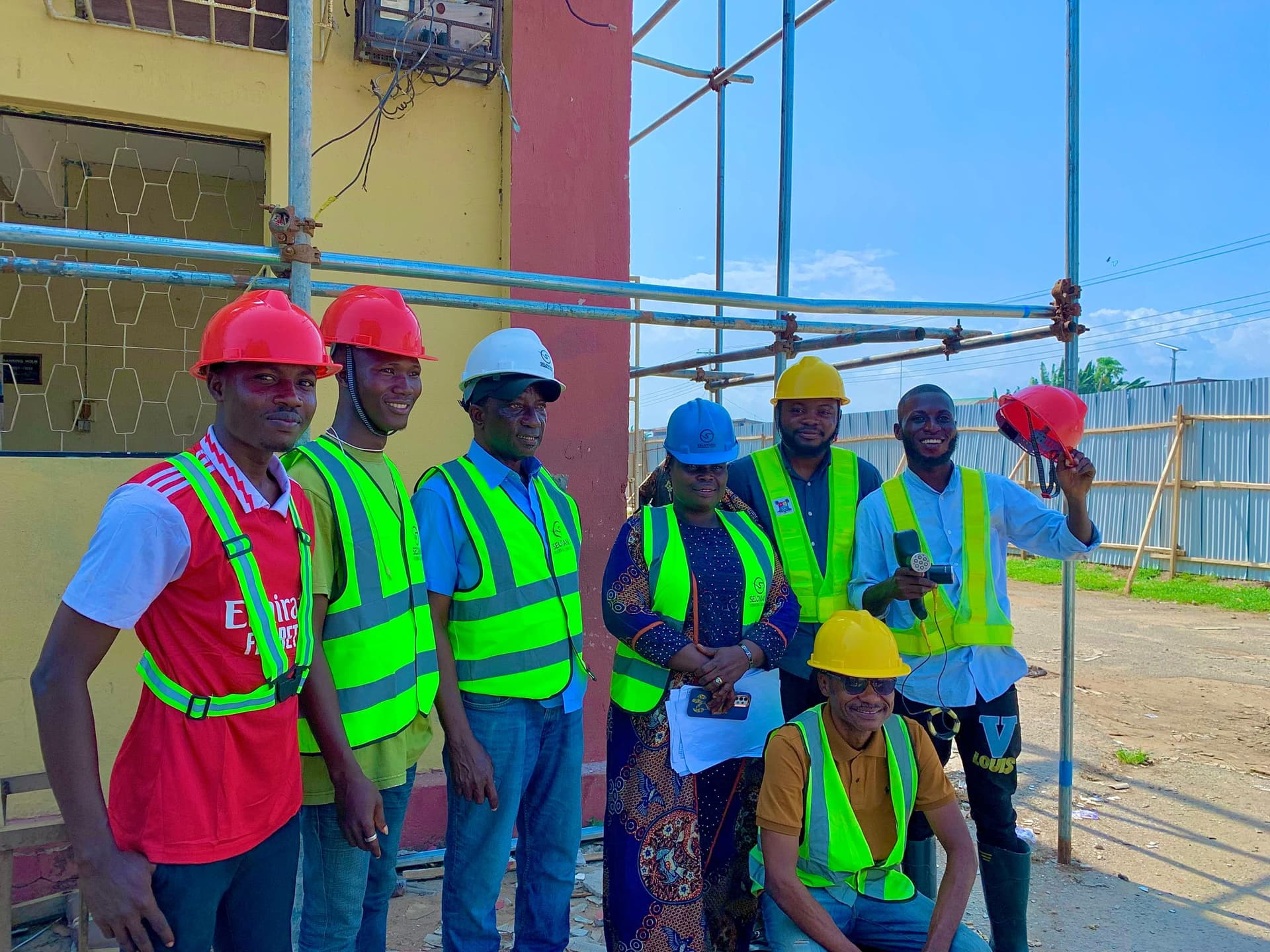 The Felmos site team outside a building under scaffolding, one of them holding an ultrasonic test instrument